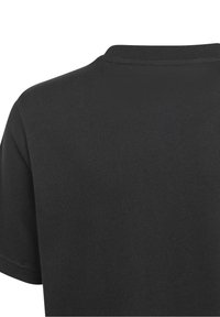 Musta puuvillapaita lyhyillä hihoilla, pyöreällä kaula-aukolla ja sileällä pinnalla. Erottuu minimalistisella suunnittelulla ilman näkyviä graafisia elementtejä tai korostuksia.