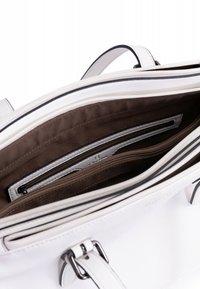 Borsa in pelle bianca con interno in tessuto marrone. Presenta più scomparti, inclusa una tasca con zip e tasche a soffietto per l'organizzazione.