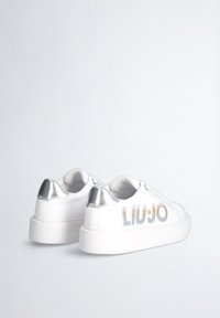 Sneakers bianchi dal design elegante, con una tomaia bianca testurizzata e un tallone argentato metallizzato. "LIU JO" è stampato in argento e oro.