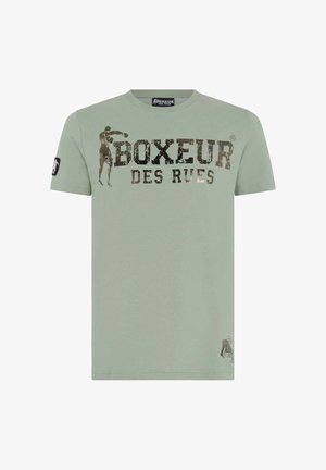 Maglietta a maniche corte verde chiaro con testo "BOXEUR DES RUES" e silhouette di un pugile come logo sul petto e una toppa sulla manica.