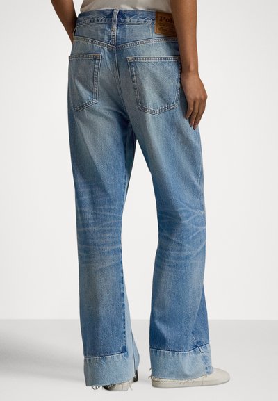 Μπλε τζιν παντελόνι καμπάνα με ξεθωριασμένο φινίρισμα, πέντε τσέπες και ξεφτισμένο τελείωμα. Απαλή ραφή και καφέ δερμάτινο ταμπελάκι στη μέση πίσω.