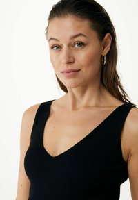 Schwarz gerippter Tanktop mit V-Ausschnitt, breiten Trägern und eng anliegender Passform. Die Textur wirkt weich und leicht dehnbar.