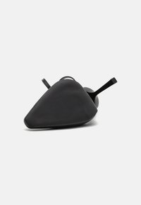 Sapatilha preta com um design triangular, superfície suave e uma tira fina. Apresenta um acabamento mate e uma sola texturizada para maior aderência.