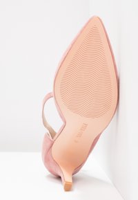 Rosa mocka pumps med spetsig tå, avsmalnande klack och strukturert sula. Har en baksnodd och en slät innerfoder. Storlek 37.