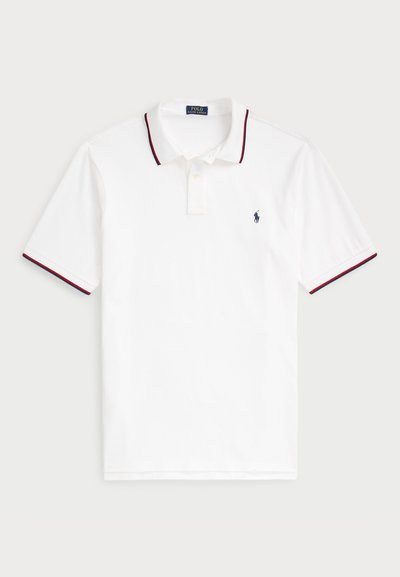 Biele polo tričko s golierom, krátkymi rukávmi a červenými a námorníckymi modrými pruhmi. Má malé námornícke logo na hrudi. Bavlnený materiál.