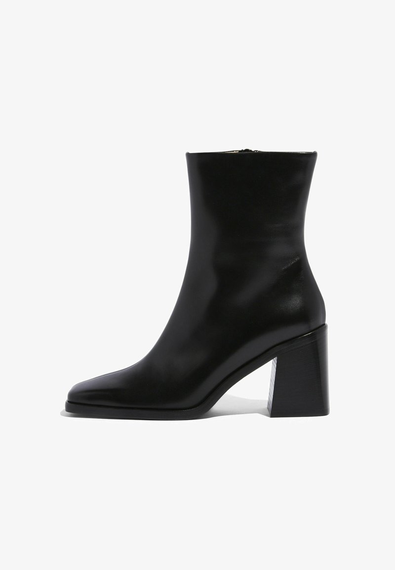 Czarne skórzane botki za kostkę z wydłużonym noskiem i geometrycznym grubym obcasem. Gładka tekstura z bocznym zamkiem błyskawicznym.