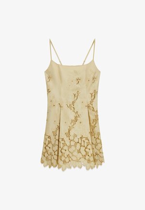Robe beige à fines bretelles avec découpes en dentelle florale et ourlet festonné, présentant un décolleté droit et un design plissé.