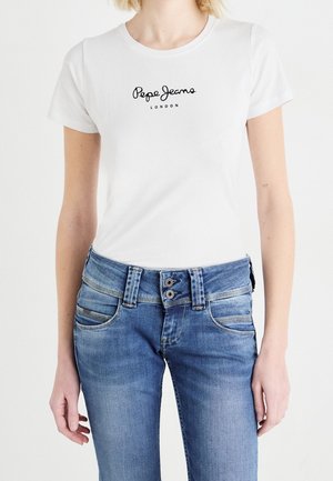 Kobieta w białej koszulce Pepe Jeans London i jasnoniebieskich dżinsach z podwójnym zapięciem, pokazana od ramion do bioder.