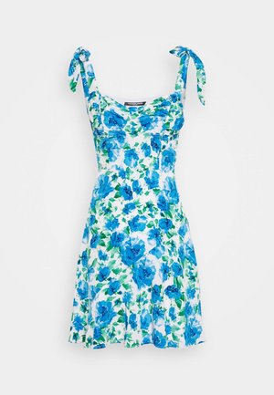 Bloemenjurk met blauwe en groene bloemenpatronen op een witte achtergrond. Heeft verstelbare strikbandjes en een aansluitend lijfje met een uitlopende rok.