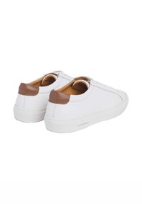Baskets en cuir blanc avec des accents de talon en cuir marron et un intérieur beige. Présente un design montante basse et une semelle en caoutchouc texturée.