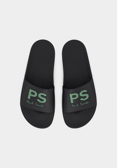 Μαύρα σανδάλια με φαρδιές λουρίδες που φέρουν πράσινα αρχικά "PS" και την υπογραφή "Paul Smith" σε καλλιγραφικά γράμματα σε κάθε λουρί.