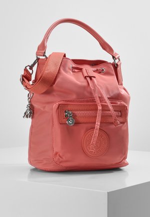 Sac seau rose corail à cordon avec poche zippée à l'avant, logo circulaire embossé, bandoulière amovible et petit porte-clés charm.