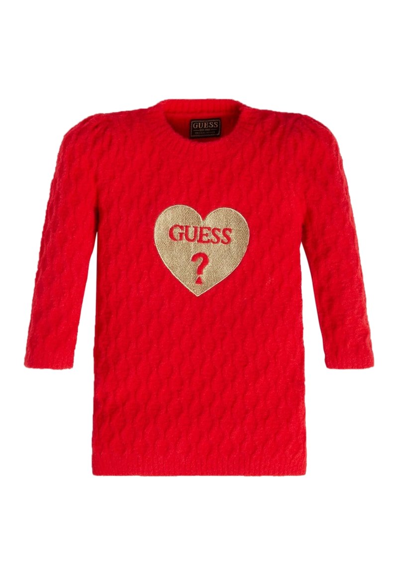 Czerwony sweter z dzianiny, z rękawami o długości trzech czwartych. Posiada teksturowany wzór oraz złotą naszywkę w kształcie serca z napisem "GUESS ?" na środku.
