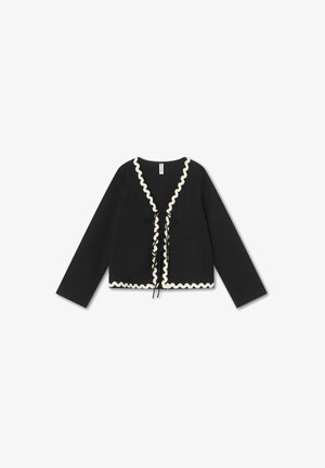 Zwarte cardigan met lange mouwen, met een V-hals en een decoratieve, geschulpte crème rand. Voorzien van een sluiting aan de voorkant met zwarte linten.