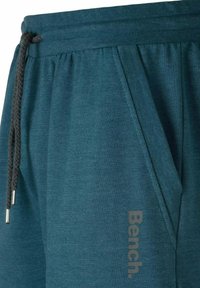 Teal Jogginghosen aus weichem Stoff, mit einem elastischen Bund und einem Kordelzug, sowie einem grauen "Bench."-Logo aufgedruckt.