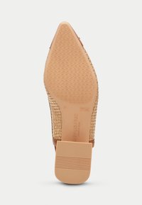 Zapato de tacón con punta afilada, parte superior de yute natural tejido, acentos en piel en color marrón, suela de goma y patrón texturizado para mayor agarre.