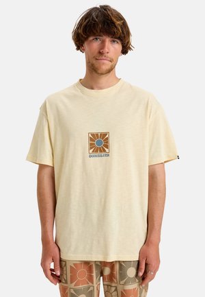 Light yellow short-sleeve t-shirt made of soft fabric, featuring a central graphic design with brown and blue accents.