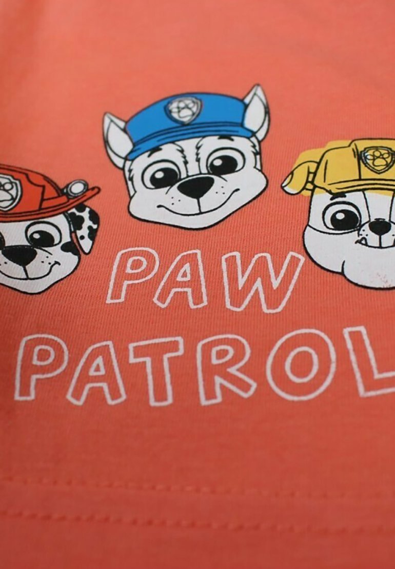 Tissu corail avec trois têtes de chien de dessin animé, chacune portant un chapeau de couleur différente. Le texte indique "PAW PATROL" en lettres blanches en gras.