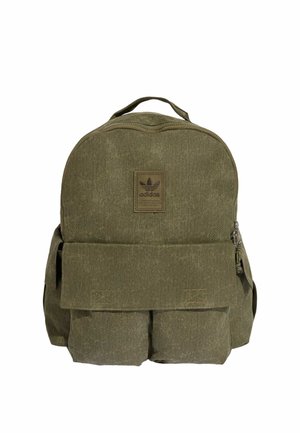 Olivgrüner Adidas Rucksack mit oberem Griff, vorderer Klapptasche, zwei unteren Vordertaschen und mittig über der Klappe angebrachten Logo-Patch.