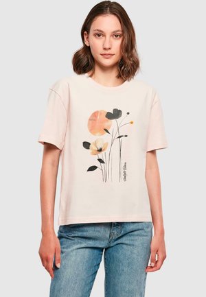 Light pink cotton t-shirt with short sleeves, featuring a floral design in black, orange, and cream, and a round neckline.