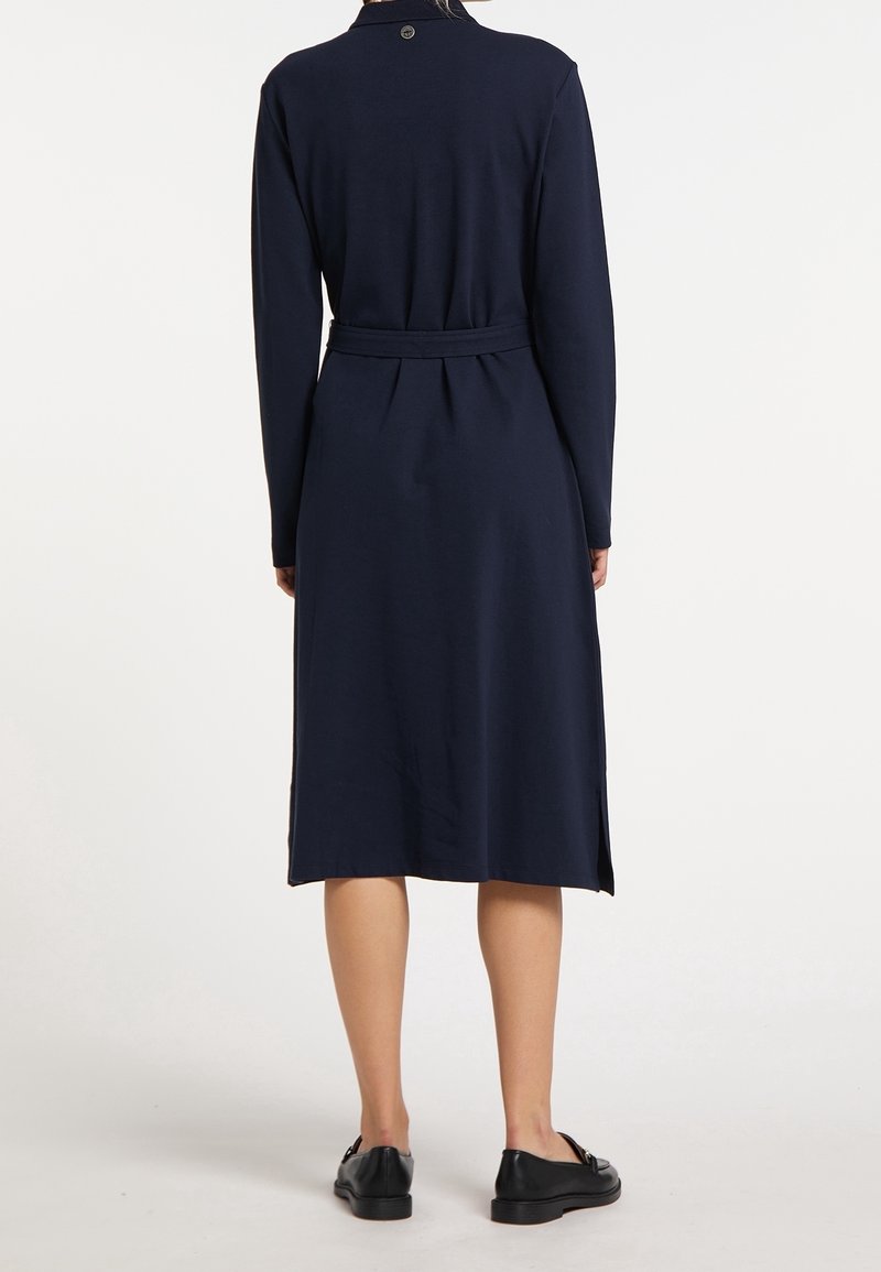 Abito lungo a maniche lunghe blu navy con cintura, pieghe sul retro e spacchi laterali; realizzato in tessuto morbido, presenta un bottone al collo.