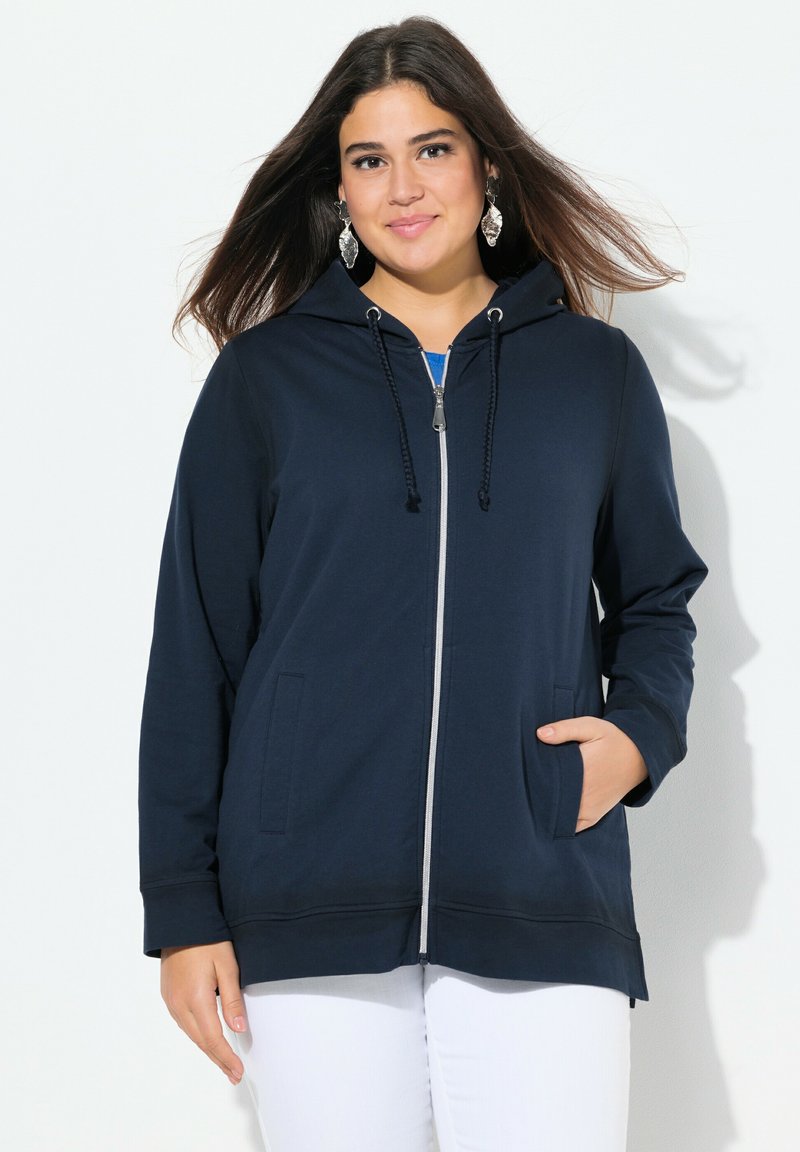 Sweat à capuche zippé bleu marine avec cordon de serrage, manches longues, deux poches avant et coupe décontractée. Texture douce avec de légers détails de couture.