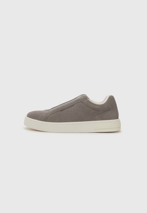 Grijze suède instappersneaker met een crèmekleurige rubberen zool, met een gladde afwerking en subtiele branding aan de zijkant. Minimalistisch ontwerp.