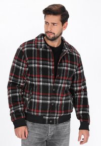 Schwarze, rote und graue karierte Jacke aus strukturiertem Stoff; mit Kragen, Knopfverschluss sowie gerippten Bündchen und Saum.}}