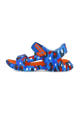 Sandalia colorida con un patrón geométrico en azul y rojo. Fabricada en material sintético con correas de Velcro ajustables y suela texturizada.