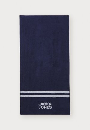 Navy towel made of soft cotton, featuring two white stripes and embroidered "JACK & JONES" logo near the bottom. Rectangular shape.