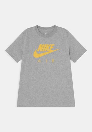 Szara, krótka koszulka Nike Air z żółtym logo i napisem na środku klatki piersiowej, ułożona płasko na białym tle.