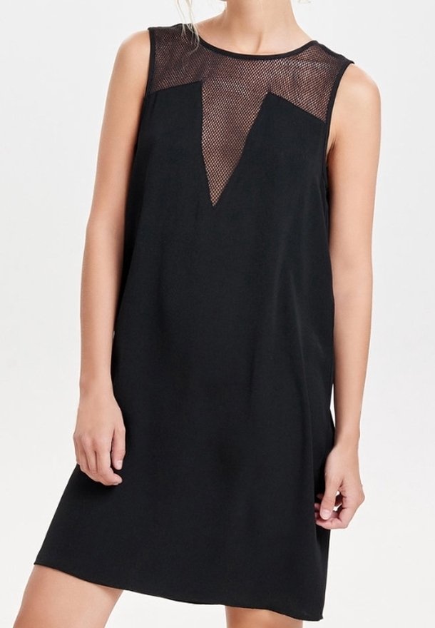 Robe noire sans manches avec un panneau en maille transparente au niveau du décolleté et de la poitrine, portée par une personne sur un fond uni.