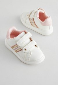 Weiße Leder-Sneaker mit zwei Klettverschlüssen, rosa Akzenten und einem strukturierten Seitestreifen. Abgerundete Zehenpartie und gepolsterte Innenauskleidung.