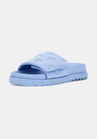 Sandali scivolati di colore azzurro chiaro con parte superiore trapuntata, caratterizzati da decorazioni ricamate azzurro chiaro e una suola testurizzata e scanalata.