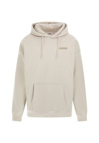 Smėlinis džemperis su gobtuvu, turintis priekinę kišenę ir reguliuojamas juostas. Ant krūtinės subtiliai atspausdintas „GUESS“ logotipas, atitinkamos spalvos.