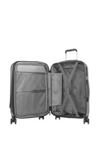 Valigia grigia con esterno rigido, due scomparti, tasche con zip, cinghie incrociate e quattro ruote per una facile manovrabilità.