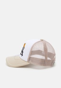 Gorra de camionero en blanco y beige, con visera curvada, parte trasera de malla y diseño bordado con un gráfico de la cabeza de un león.