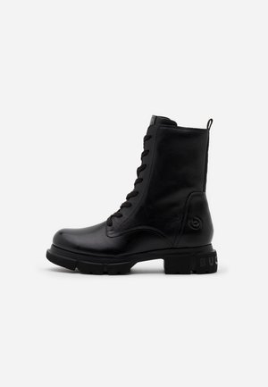 Bottine noire en cuir à lacets, semelle épaisse et détail de talon marqué, profil latéral sur fond clair uni.