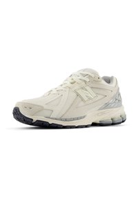 Beige and grey New Balance running shoe with mesh and synthetic panels, black sole, and cushioned heel design.