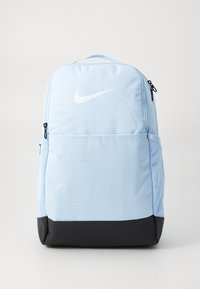 Lichtblauwe rugzak van textuur-stof, met een zwarte onderkant en een wit Nike-logo aan de voorkant. Bevat ritsen en gaas zijzakken.