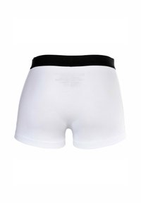 Boxer shorts blancos con una cinturilla elástica negra, hechos de un material suave, con un diseño sencillo y una textura lisa.