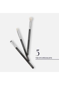 Three black-handled eye makeup brushes labeled eyebrow liner, detail crease/liner, and eyeshadow blender, with text "5 The Eye Specialists."
