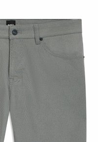Gray patterned trousers made of fabric with a small dot design, featuring a button closure, belt loops, and front pockets.