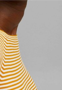 Gestreifter Stoff in Gelb und Weiß, mit einer glatten, gestrickten Textur. Das Design umfasst dünne, horizontal abwechselnde Streifen.