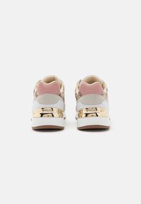 Sneaker con tomaia in canvas beige e rosa, con dettagli dorati sul tallone e una suola intermedia bianca. Retro texturizzato con logo "GUESS".