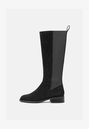 Knæhøye svarte sueboots har et teksturert stoffpanel, en rund tå og en lav blokk hæl med en trekksløyfe bak.