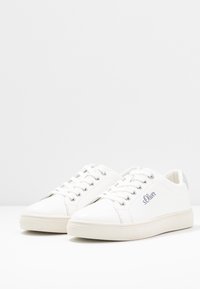 Weiße Leder-Sneaker mit glatter Textur, Schnürdesign, silberner Ferse und gesticktem Logo an der Seite. Abgerundete Zehenform.