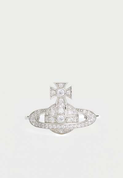 Sølvbroche formet som en planet med et kors, prydet med klare krystaller, med cirkulære og ovale elementer i et tekstureret design.