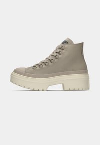 Beige Hochtop-Sneaker aus glattem Material, mit einer dicken weißen Plattformsohle, Metallösen und einer verstärkten Zehenkappe.
