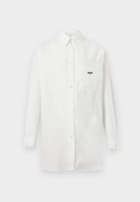 Λευκό πουκάμισο με μακριά μανίκια και κουμπιά, με τσέπη στο στήθος όπου εμφανίζεται μικρό μαύρο κείμενο με το λογότυπο "Moschino".